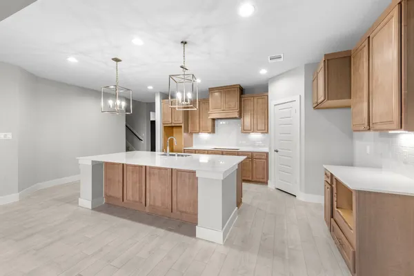 a large kitchen with kitchen island a sink stainless steel appliances and cabinets