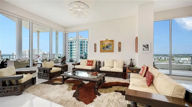 a living room with furniture large window and a table