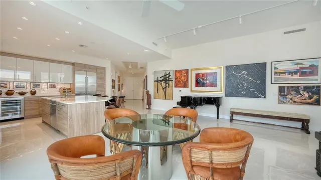 a living room with furniture a flat screen tv and kitchen view