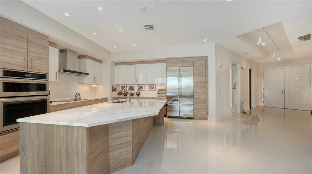 111 South Pineapple Avenue, Unit 1210 Sarasota, FL 34236 - Photo 29 of 54 a large kitchen with stainless steel appliances a large counter top a stove and a refrigerator