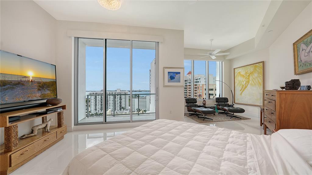 111 South Pineapple Avenue, Unit 1210 Sarasota, FL 34236 - Photo 39 of 54 a bedroom with a bed a flat screen tv and large windows