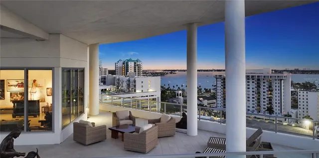 a living room with furniture a lamp and large window