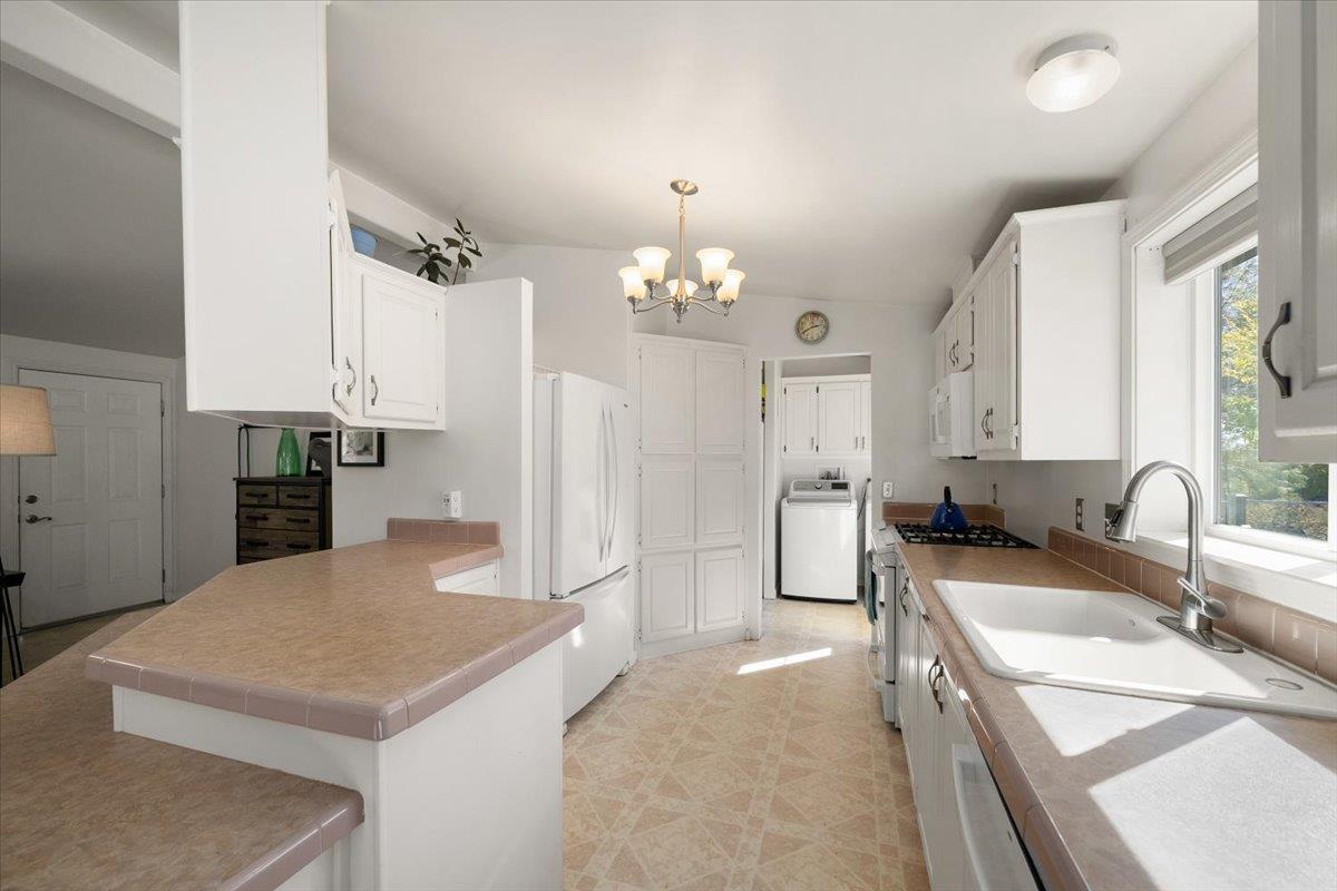 7155 Stewart Mine Road Placerville, CA 95667 - Photo 14 of 68 a kitchen with a sink a stove a refrigerator and a fireplace