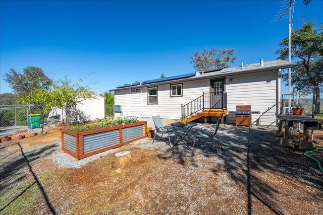 a backyard of a house with table and chairs