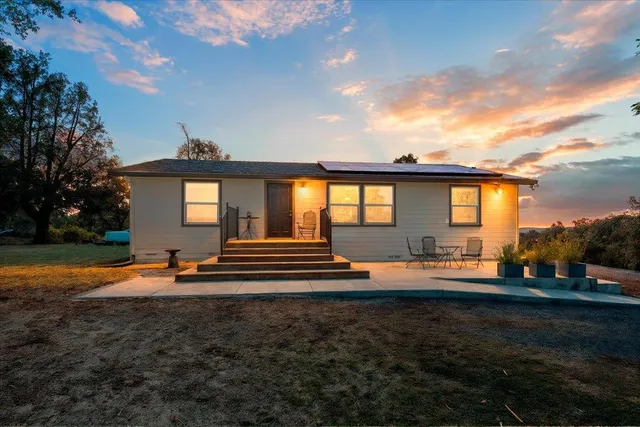 a view of a house with backyard and sitting area