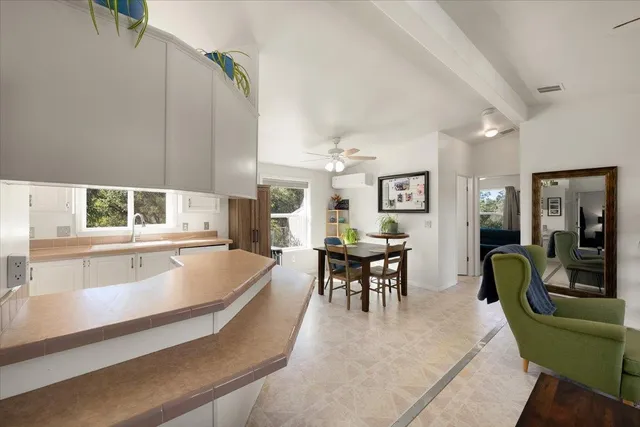 a dining hall with stainless steel appliances kitchen island granite top and furniture