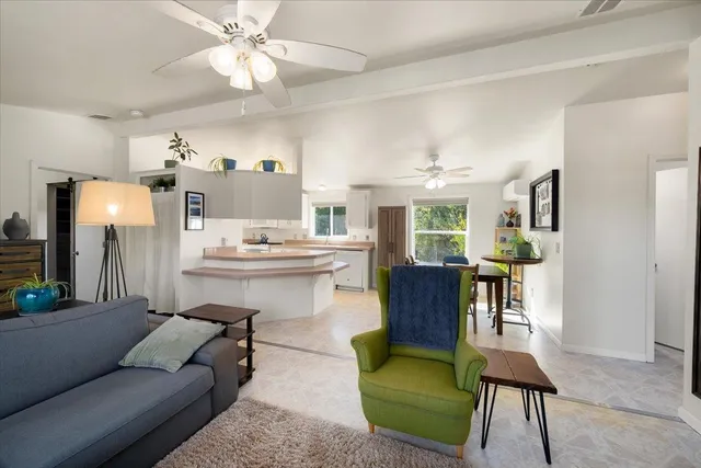 a living room with furniture and a dining table with kitchen view
