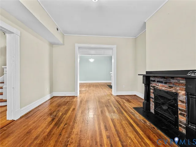 a view of a livingroom with wooden floor and a fireplace