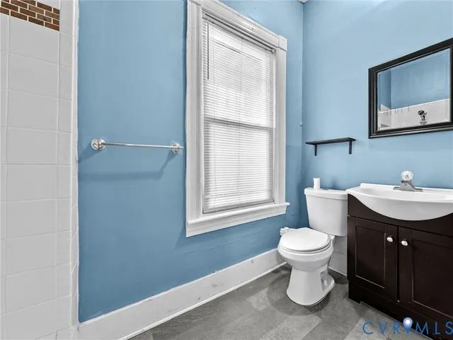 a bathroom with a sink toilet a mirror and window