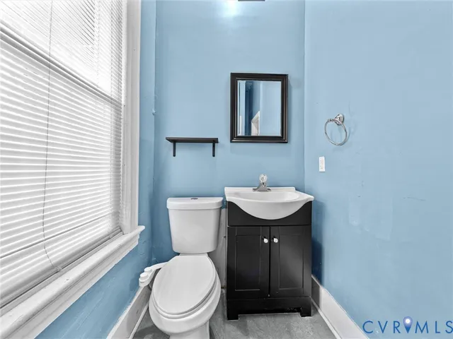 a bathroom with a toilet a sink and mirror