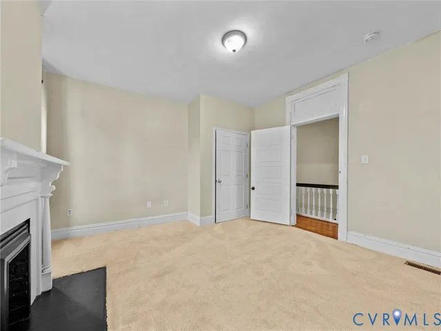 an empty room with windows and fireplace