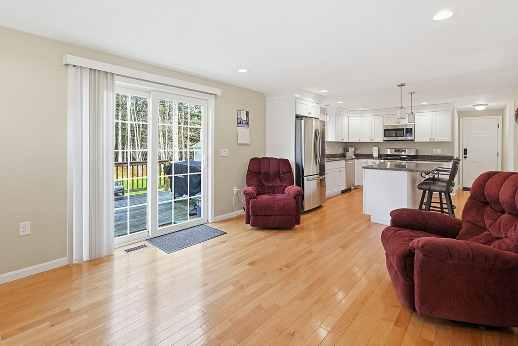 24 Reservoir Road Pembroke, MA 02359 - Photo 19 of 42 a living room with furniture a flat screen tv and kitchen view