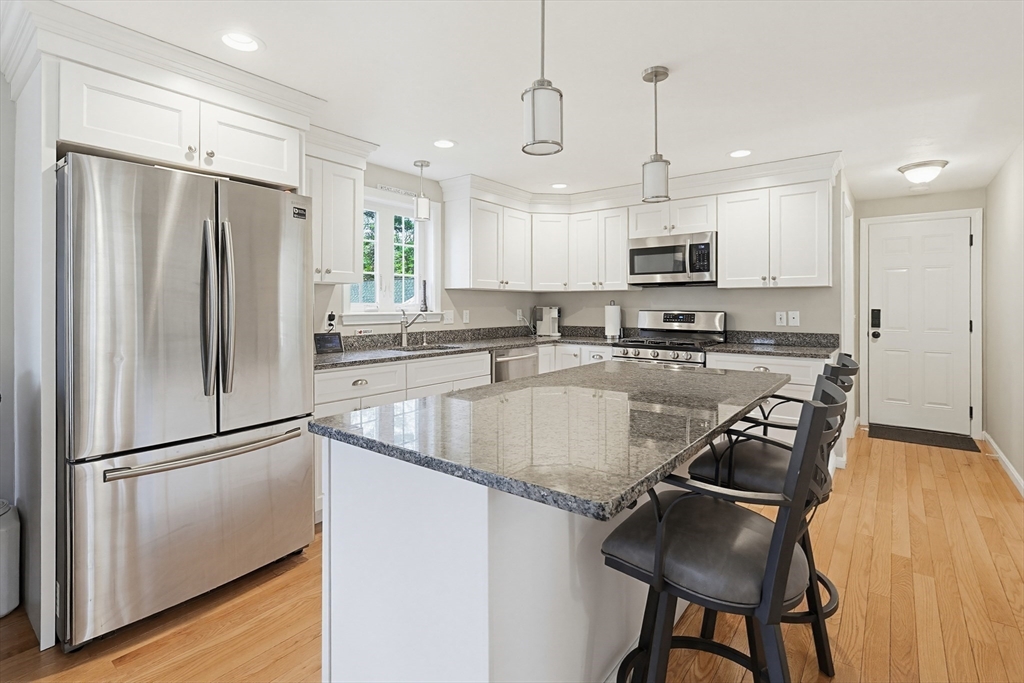 24 Reservoir Road Pembroke, MA 02359 - Photo 10 of 42 a kitchen with kitchen island granite countertop a sink a counter space stainless steel appliances and cabinets