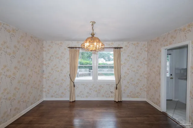 a view of a room with wooden floor staircase and a kitchen