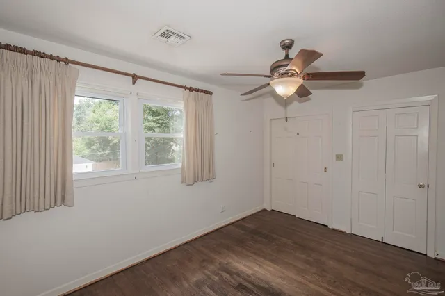 a kitchen with a sink and dishwasher with white cabinets