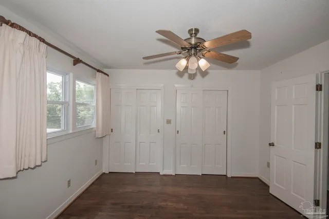 a view of a kitchen with white cabinets and wooden floor