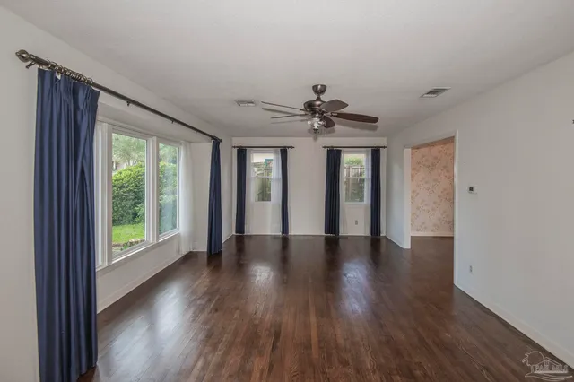 a view of a livingroom with wooden floor and a ceiling fan