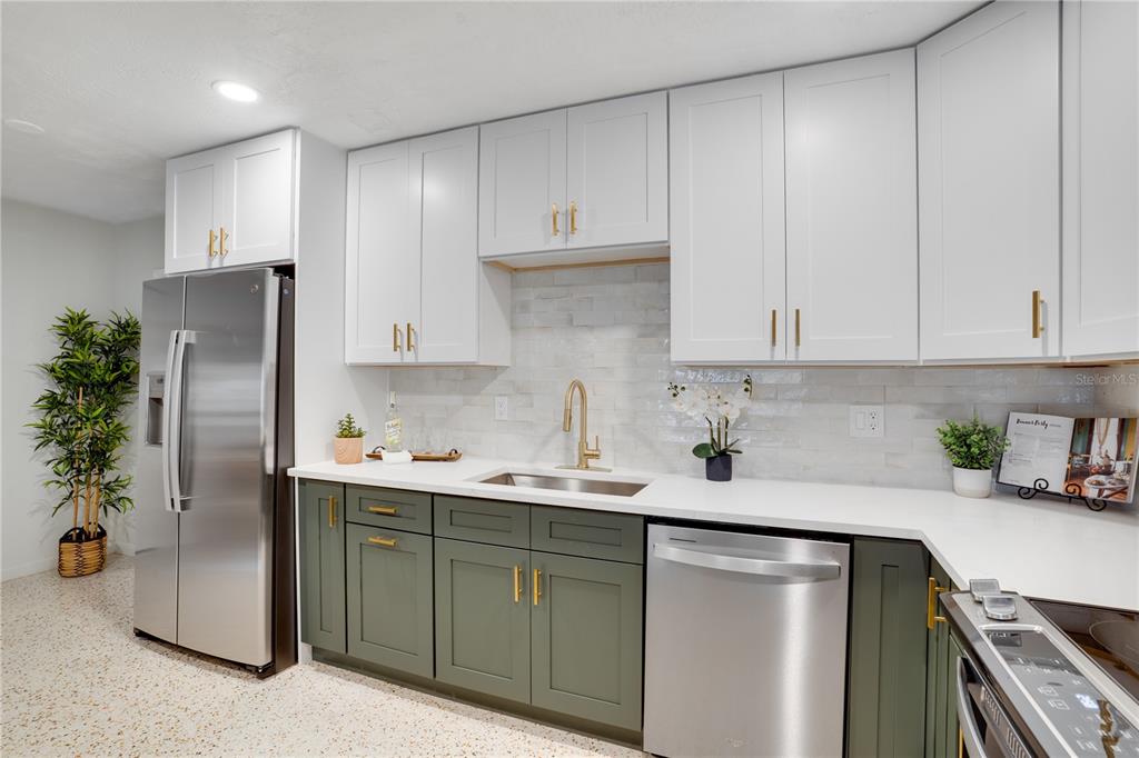 5135 101st Street North St. Petersburg, FL 33708 - Photo 15 of 46 a kitchen with stainless steel appliances granite countertop a refrigerator sink and cabinets