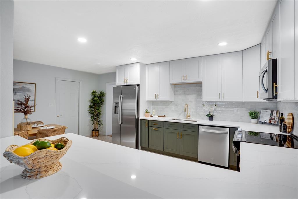 5135 101st Street North St. Petersburg, FL 33708 - Photo 16 of 46 a kitchen with stainless steel appliances granite countertop a sink and a refrigerator