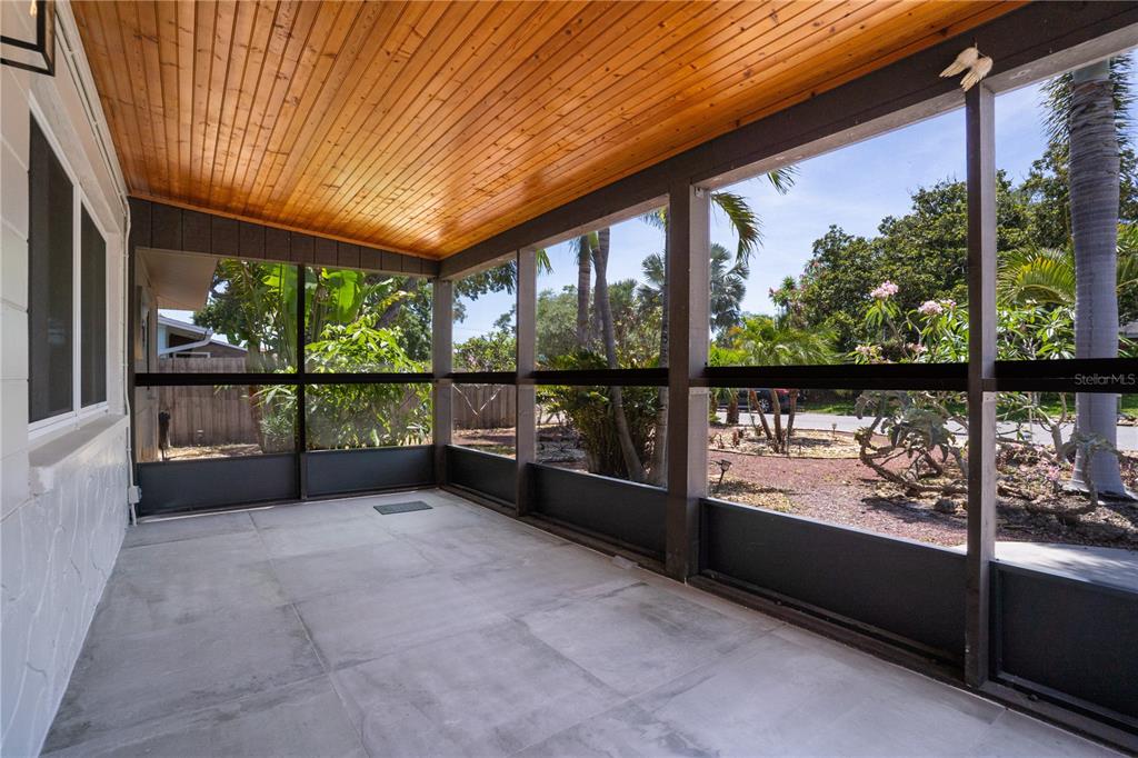 5135 101st Street North St. Petersburg, FL 33708 - Photo 5 of 46 an empty room with wooden floor and outdoor seating