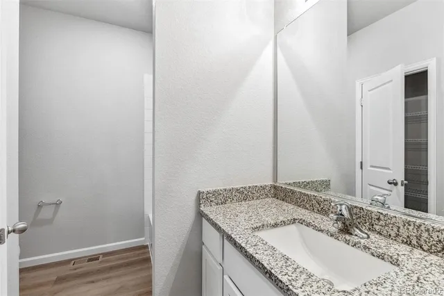 a bathroom with a granite countertop sink and a mirror