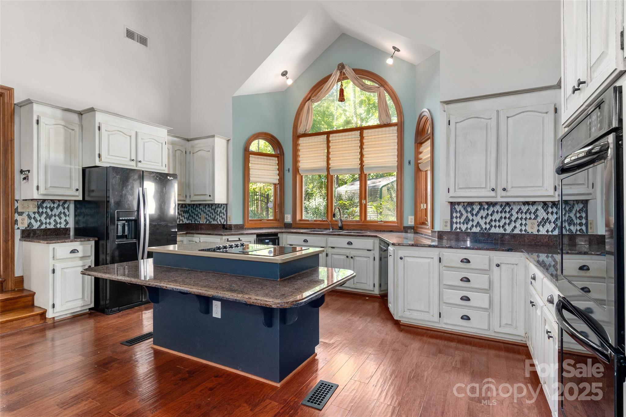909 Baron Road Waxhaw, NC 28173 - Photo 15 of 46 a kitchen with stainless steel appliances granite countertop a refrigerator a sink dishwasher a stove and white countertops with wooden floor
