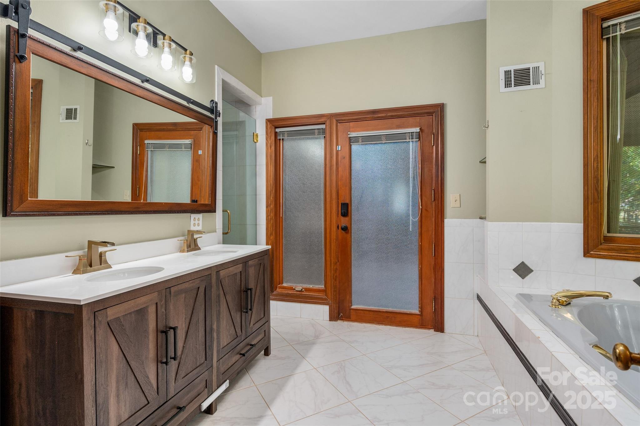 909 Baron Road Waxhaw, NC 28173 - Photo 19 of 46 a bathroom with a tub a sink and a mirror