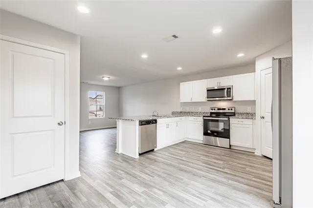 a kitchen with stainless steel appliances a refrigerator and a stove top oven