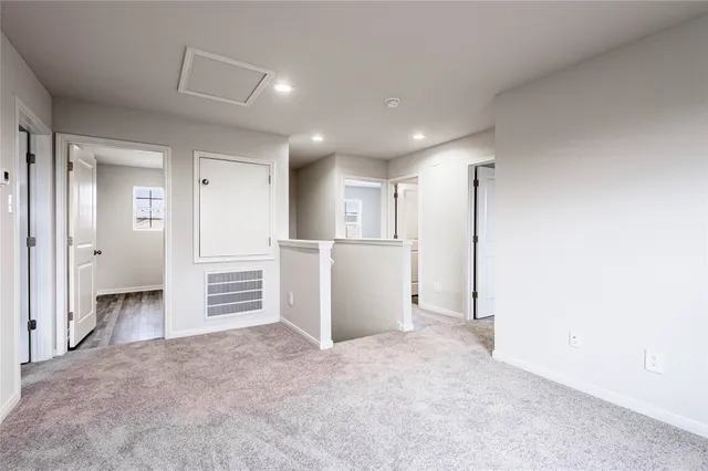 an empty room with closet and wooden kitchen