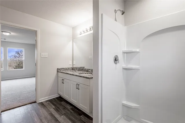 a bathroom with a granite countertop sink toilet and shower