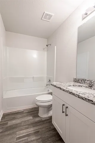 a bathroom with a granite countertop sink toilet a large mirror and shower