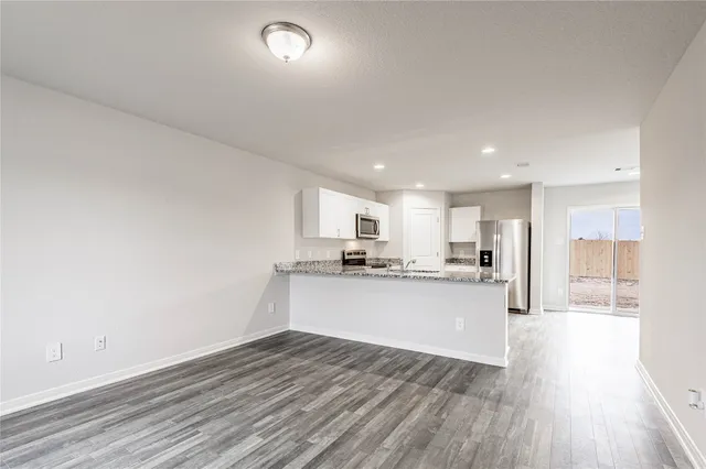 a kitchen with a sink and wooden floor