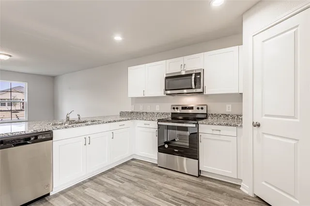 a kitchen with granite countertop a sink and steel appliances