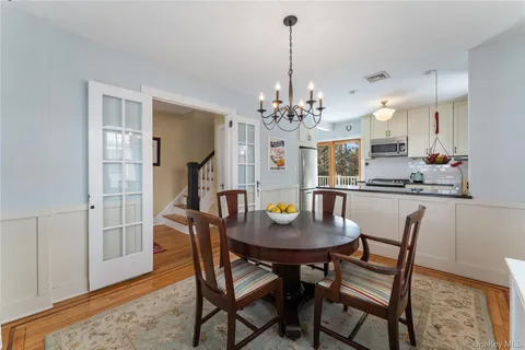 a dining room with furniture a chandelier and wooden floor