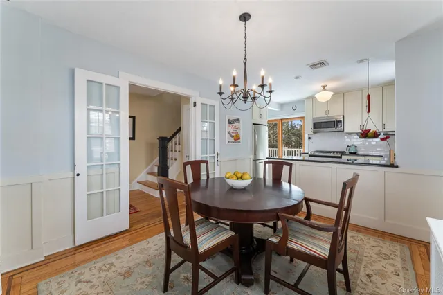 a dining room with furniture a chandelier and wooden floor