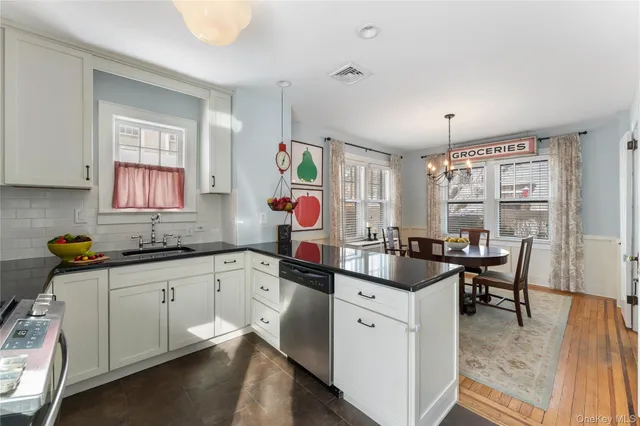 a kitchen with granite countertop a sink stove and cabinets