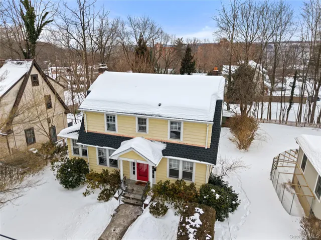a view of a white house with a yard covered in snow