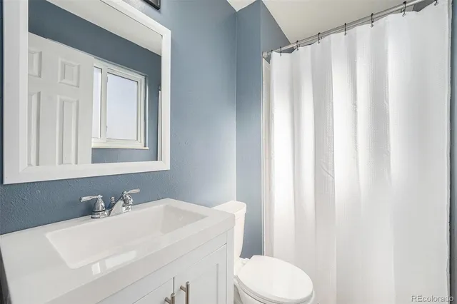 a bathroom with a sink a toilet and a mirror