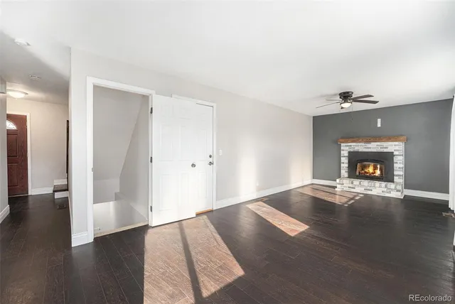 an empty room with wooden floor and fireplace
