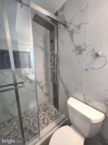 a white toilet sitting next to a shower