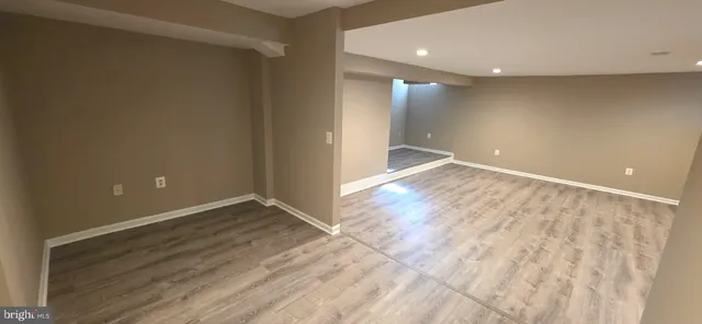 a view of an empty room with wooden floor and closet