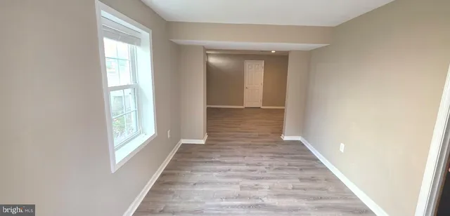 a view of a hallway with wooden floor and windows