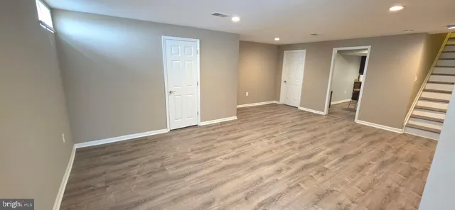 an empty room with wooden floor and door