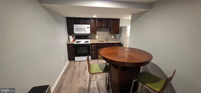 a kitchen with sink refrigerator dining table and chairs