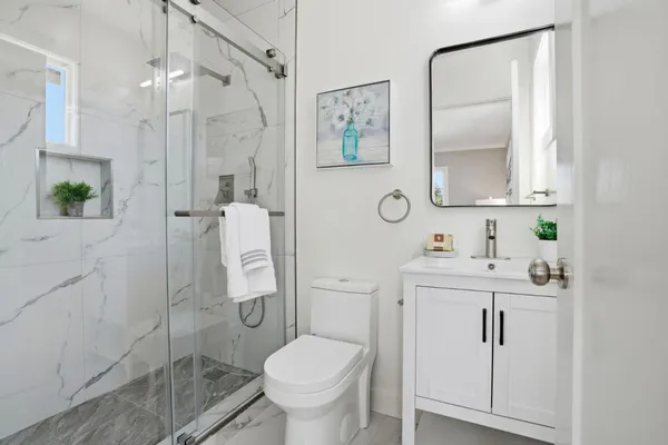 a bathroom with a granite countertop sink toilet and shower
