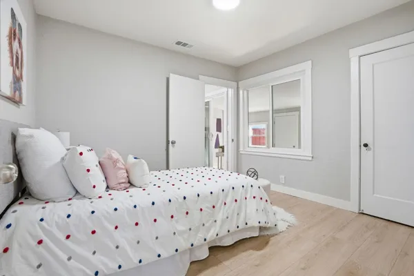 a bedroom with a bed and wooden floor