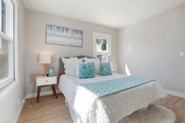 a bedroom with a bed and a painting on the wall