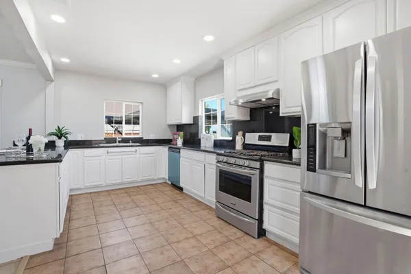 a kitchen with stainless steel appliances a refrigerator sink stove microwave and cabinets