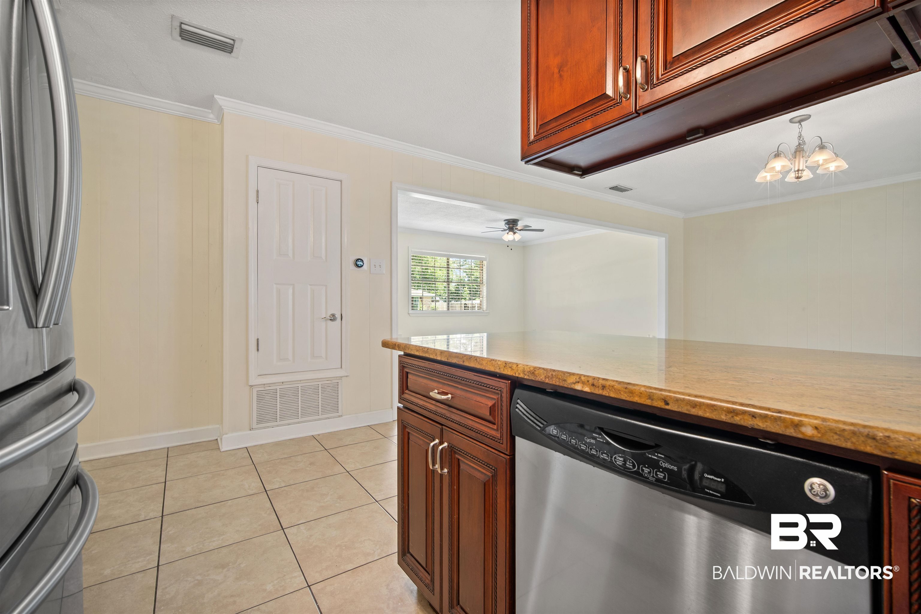 1325 Pawnee Circle Saraland, AL 36571 - Photo 10 of 26 Kitchen with appliances with stainless steel finishes, crown molding, light tile patterned flooring, a chandelier, and light stone countertops