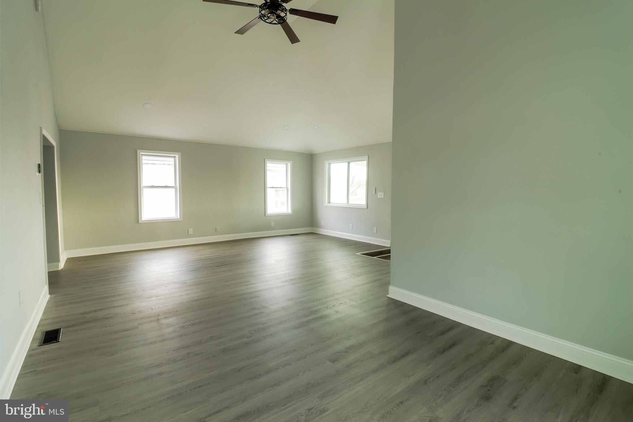 315 Riverside Drive Baltimore, MD 21221 - Photo 6 of 22 an empty room with wooden floor and windows